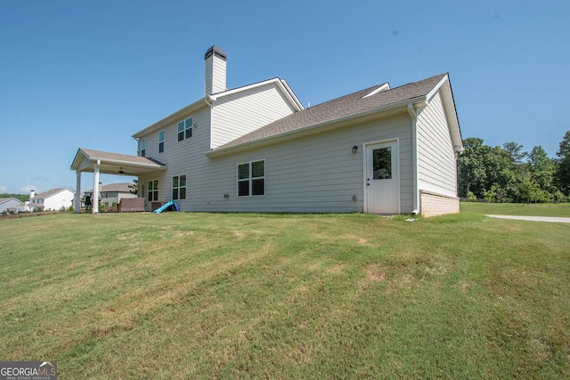 rear view of house with a yard and a chimney