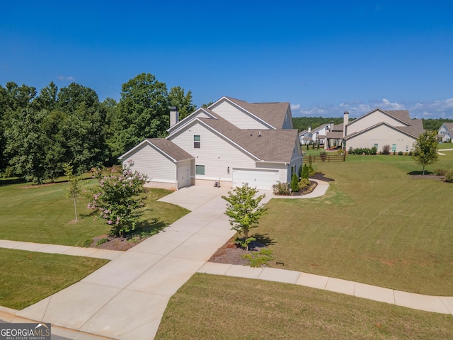 view of front facade with a garage, driveway, a chimney, and a front yard