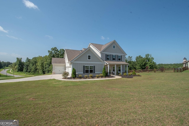 view of front of home with a front yard, fence, driveway, a garage, and board and batten siding