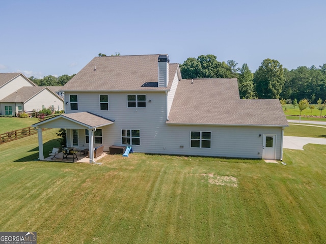 back of property with a patio, fence, a yard, a shingled roof, and a chimney