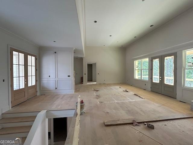 unfurnished living room featuring french doors and a healthy amount of sunlight