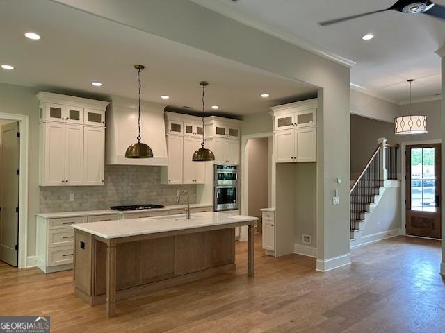 kitchen with double oven, tasteful backsplash, a sink, baseboards, and black stovetop