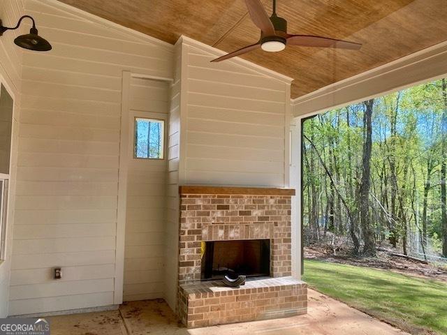 view of patio featuring an outdoor brick fireplace and a ceiling fan