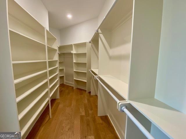 walk in closet with wood finished floors