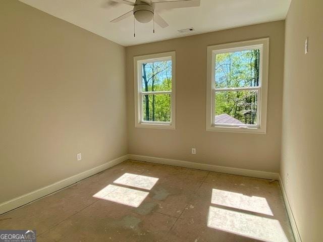 spare room with ceiling fan, visible vents, and baseboards
