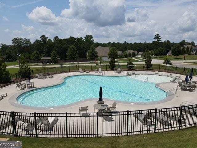 pool featuring fence and a patio area