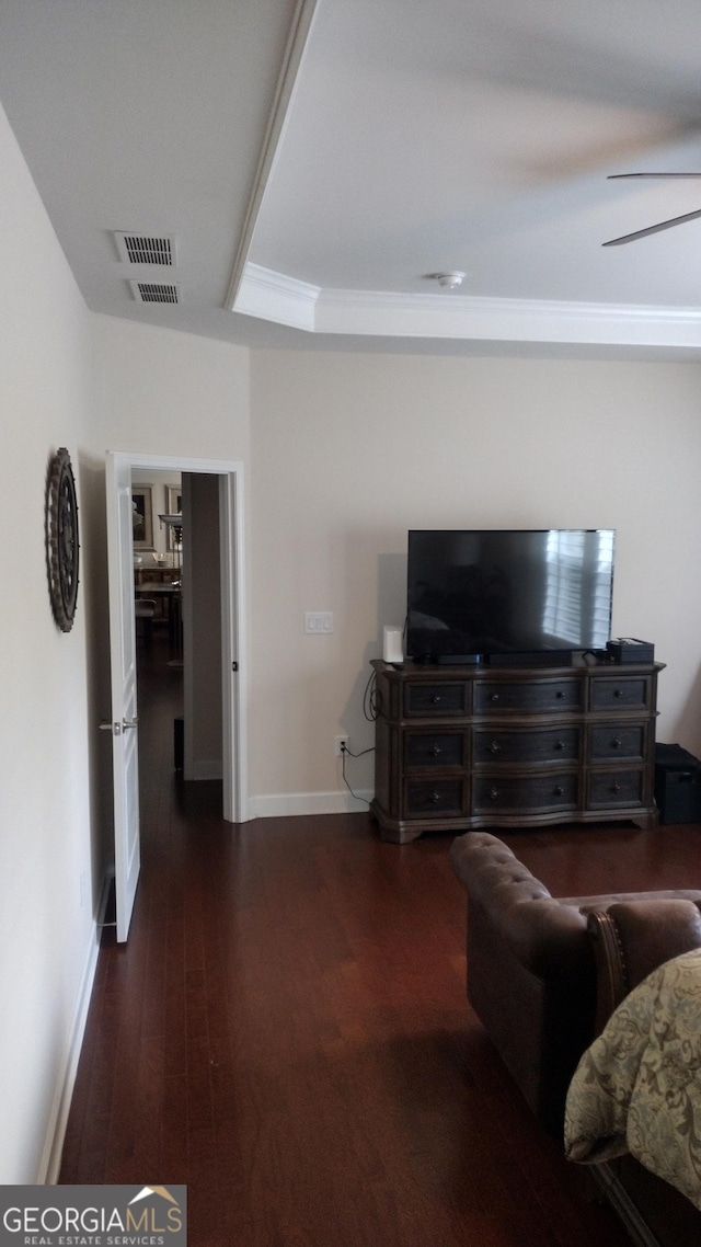 living room with dark hardwood / wood-style flooring and a raised ceiling