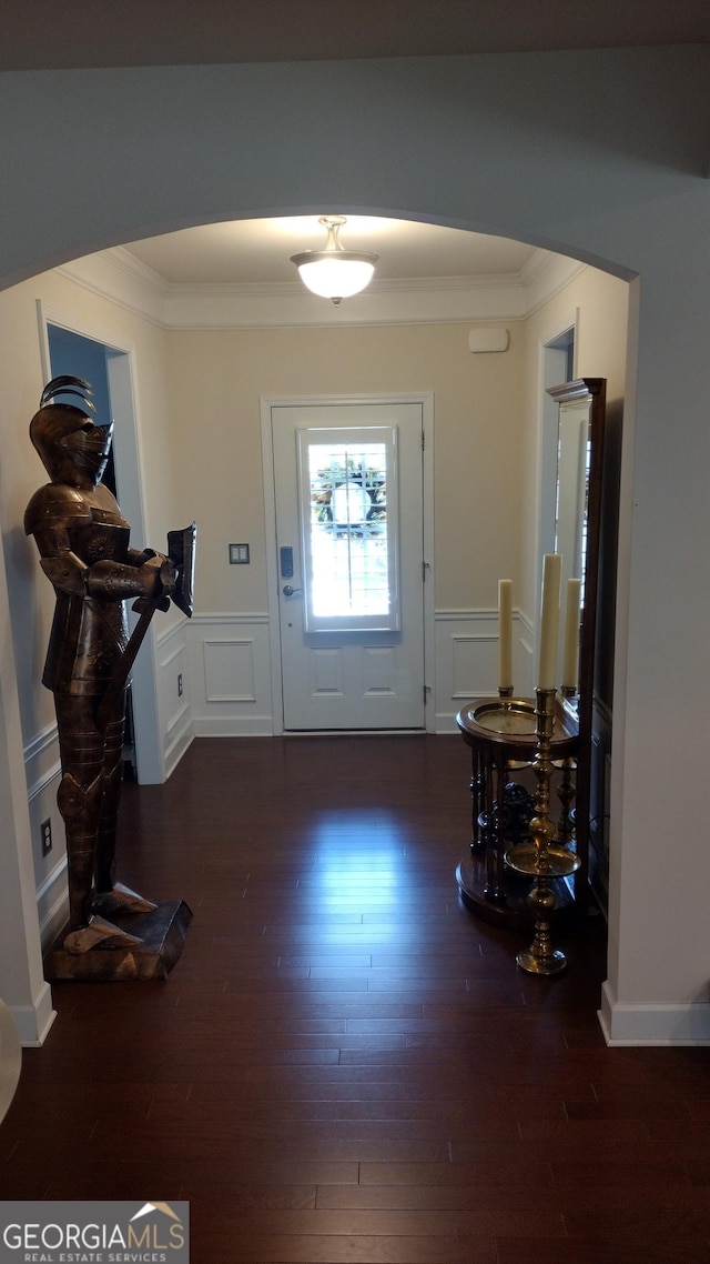 foyer featuring crown molding and dark wood-type flooring