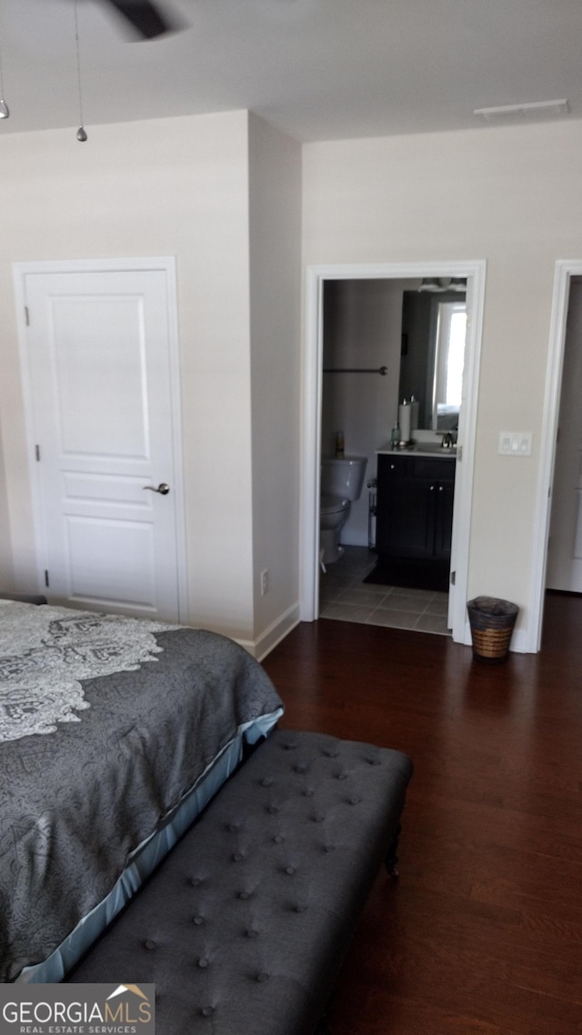 bedroom featuring dark wood-type flooring, connected bathroom, and ceiling fan