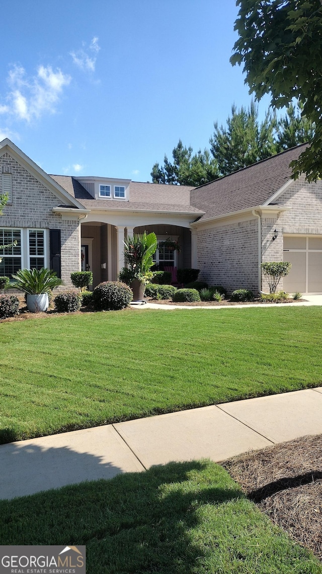 view of front of property featuring a garage and a front lawn