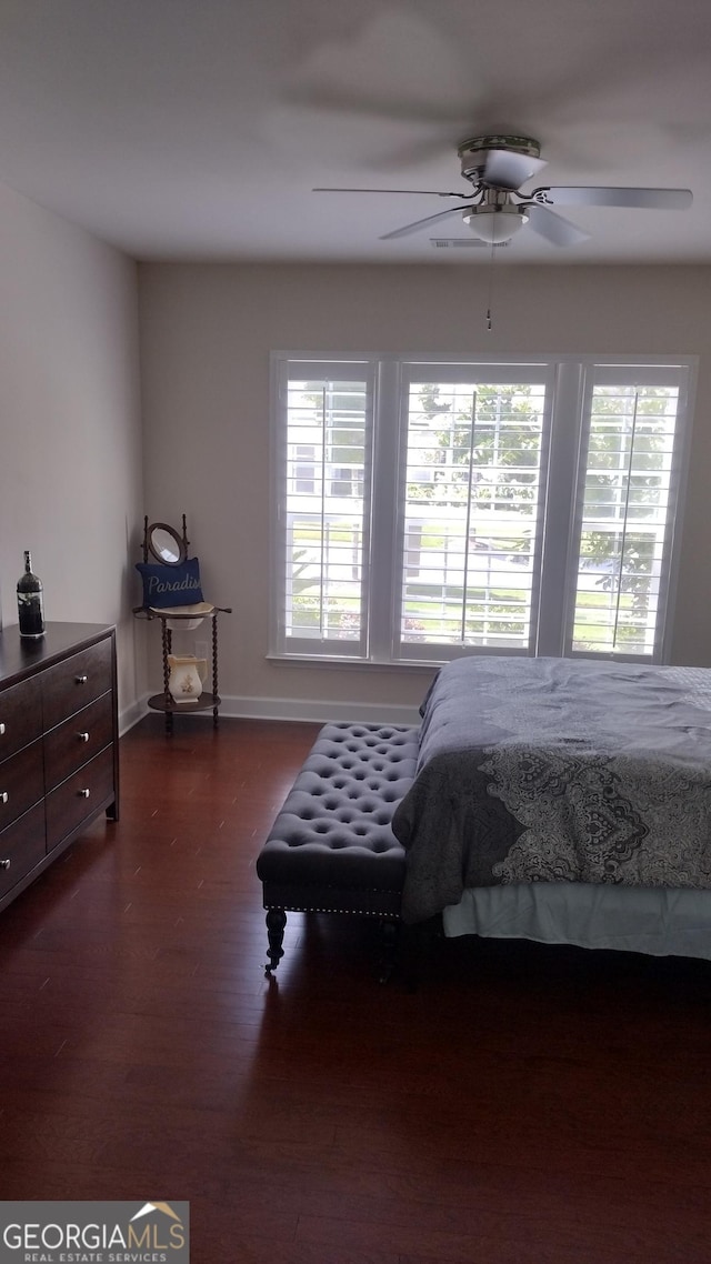 bedroom with multiple windows, dark hardwood / wood-style floors, and ceiling fan