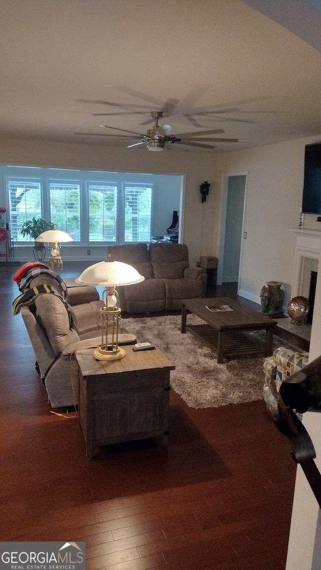 living room with dark hardwood / wood-style flooring and ceiling fan