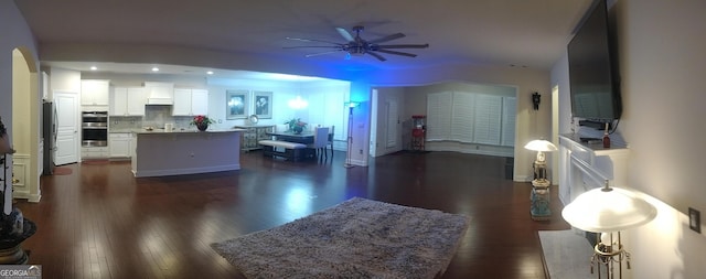 living room with dark hardwood / wood-style floors and ceiling fan