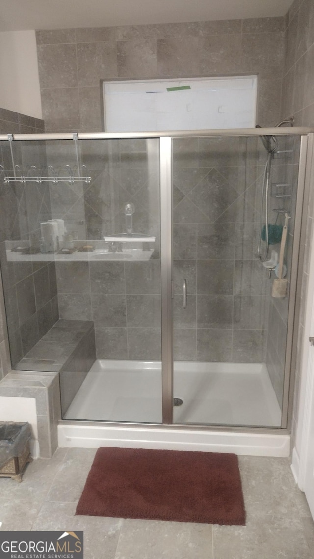 bathroom featuring tile patterned flooring and a shower with shower door