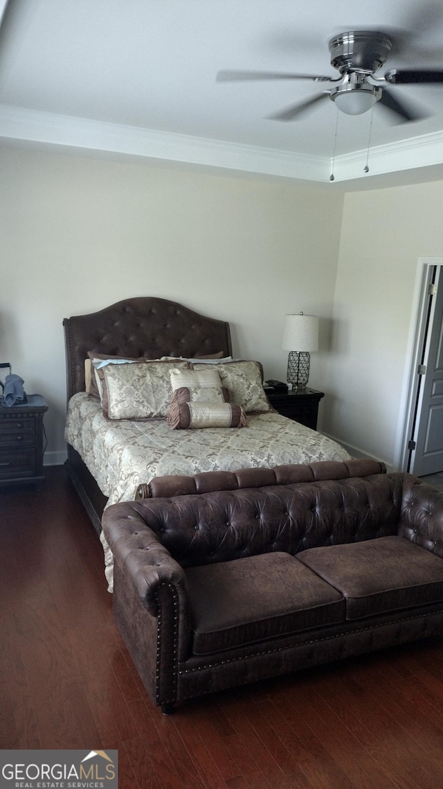 bedroom featuring dark hardwood / wood-style flooring, ornamental molding, and ceiling fan