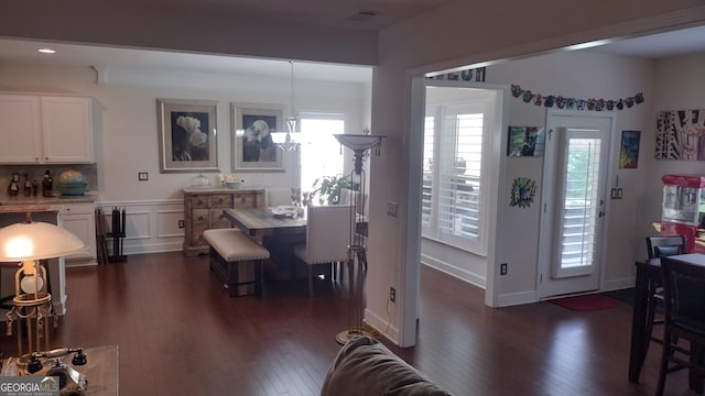 dining area with dark wood-type flooring, a chandelier, and a wealth of natural light