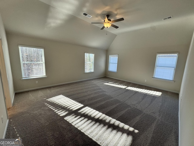 empty room with dark carpet, ceiling fan, and lofted ceiling