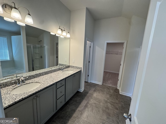 bathroom with vanity, separate shower and tub, and vaulted ceiling