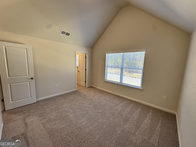 unfurnished bedroom with light carpet and lofted ceiling