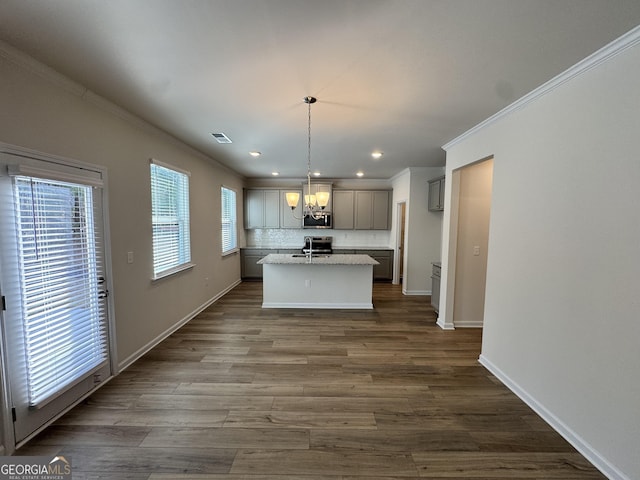 kitchen with gray cabinetry, hanging light fixtures, an island with sink, wood-type flooring, and stainless steel appliances