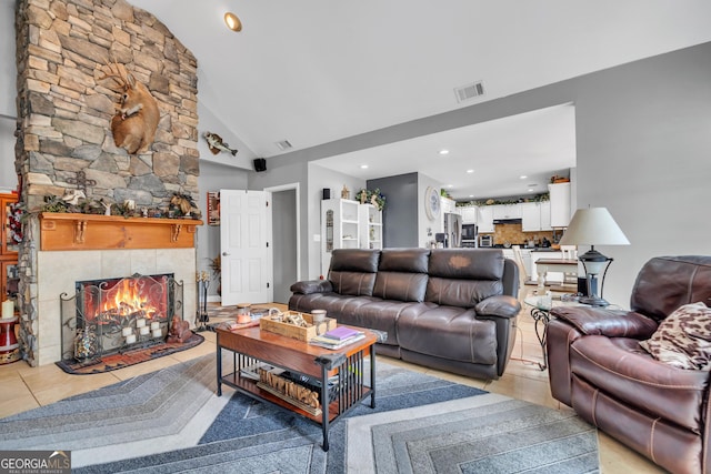 tiled living room featuring a tile fireplace and high vaulted ceiling