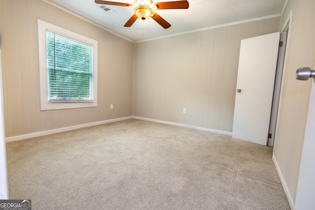 carpeted empty room with ceiling fan and crown molding