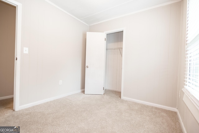 unfurnished bedroom with light carpet, a closet, and crown molding