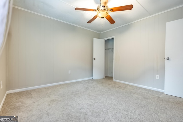 carpeted spare room featuring ceiling fan and ornamental molding