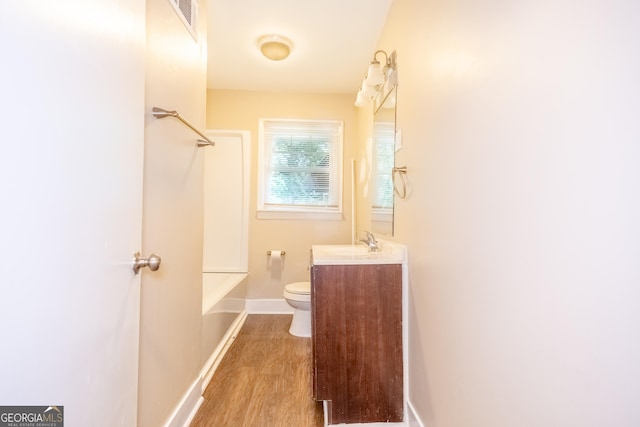 full bathroom with shower / bathing tub combination, wood-type flooring, vanity, and toilet