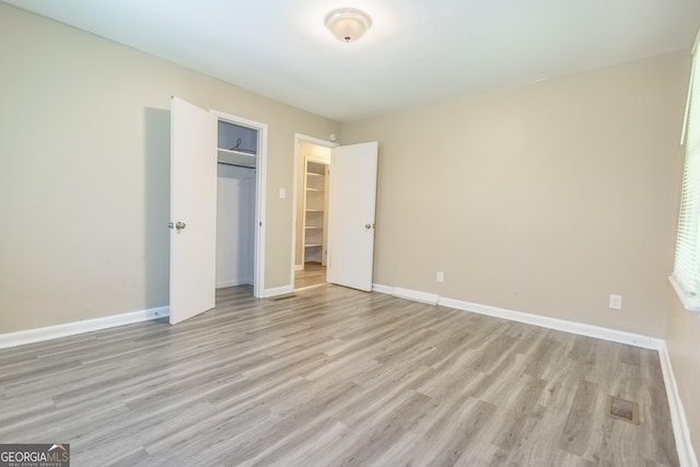 unfurnished bedroom featuring light wood-type flooring and a closet