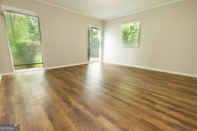 unfurnished room with crown molding, a textured ceiling, and hardwood / wood-style flooring