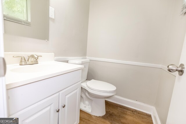 bathroom with vanity, wood-type flooring, and toilet