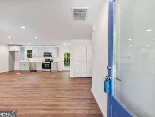 unfurnished living room with light wood-type flooring and sink