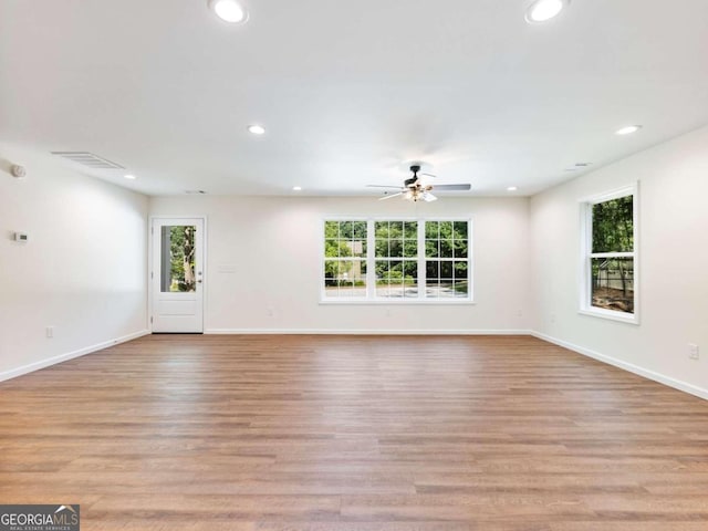 unfurnished living room featuring light hardwood / wood-style flooring, ceiling fan, and a wealth of natural light