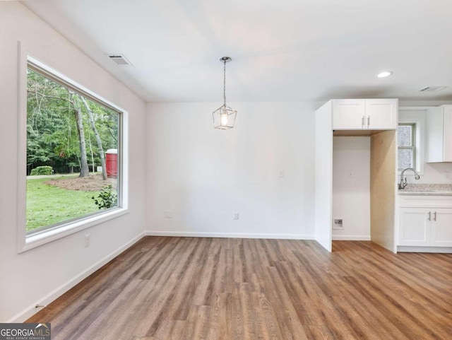 unfurnished dining area featuring light hardwood / wood-style floors, sink, and a wealth of natural light