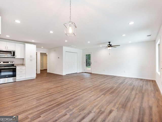 unfurnished living room featuring ceiling fan and light hardwood / wood-style floors