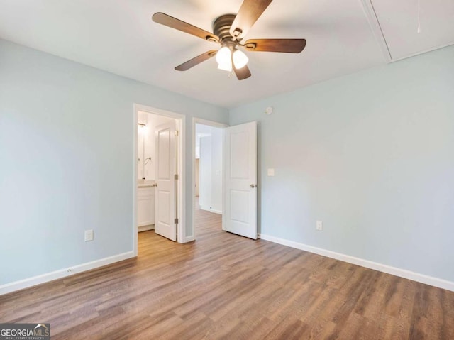 unfurnished bedroom featuring ensuite bath, light hardwood / wood-style flooring, and ceiling fan