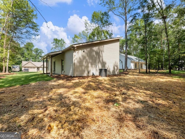 view of side of property featuring a yard and central air condition unit