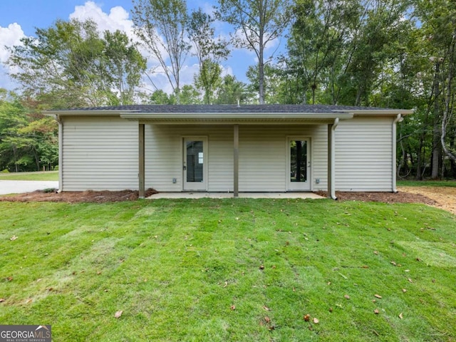 back of property with a yard and a patio