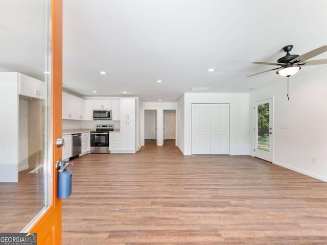 unfurnished living room with light hardwood / wood-style flooring and ceiling fan