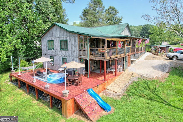 rear view of house with a deck and a lawn