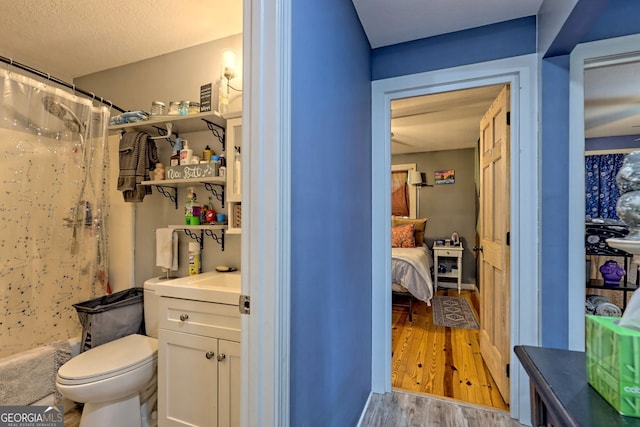 bathroom with vanity, a textured ceiling, hardwood / wood-style flooring, and toilet