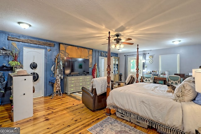 bedroom with light hardwood / wood-style floors, a textured ceiling, and ceiling fan