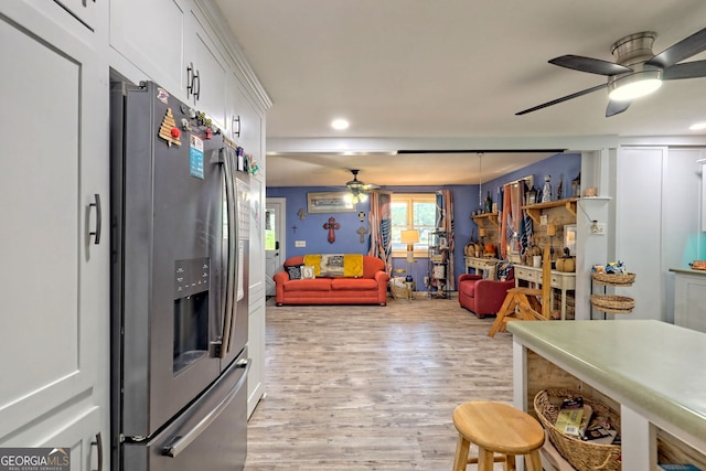 kitchen featuring white cabinets, stainless steel fridge, light wood-type flooring, and ceiling fan