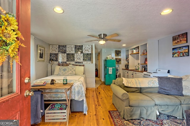 living room featuring light hardwood / wood-style floors, a textured ceiling, and ceiling fan