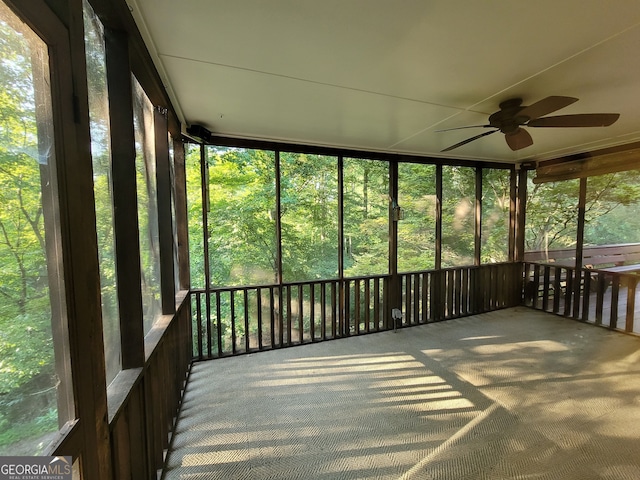 unfurnished sunroom featuring ceiling fan