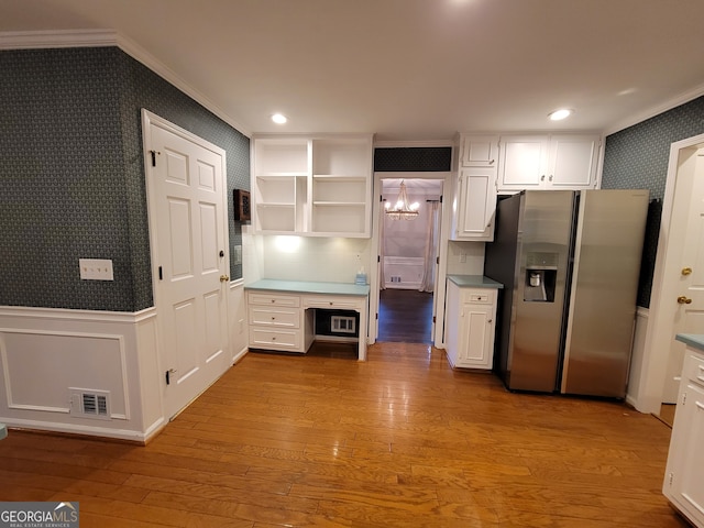 kitchen featuring stainless steel fridge with ice dispenser, white cabinetry, ornamental molding, and light hardwood / wood-style floors