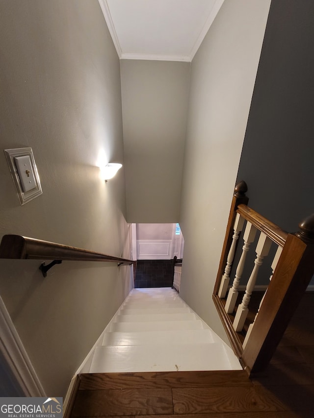 stairs featuring ornamental molding and hardwood / wood-style flooring