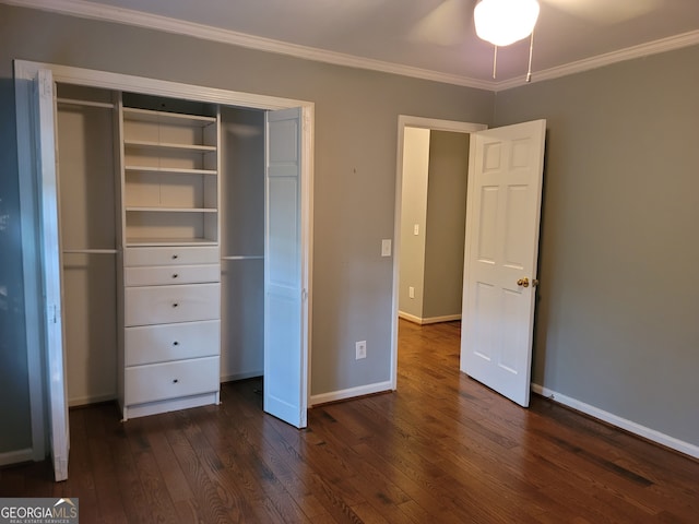 unfurnished bedroom with ceiling fan, dark wood-type flooring, ornamental molding, and a closet