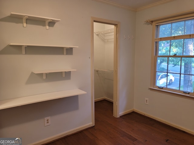 unfurnished office featuring dark hardwood / wood-style floors, crown molding, and a wealth of natural light